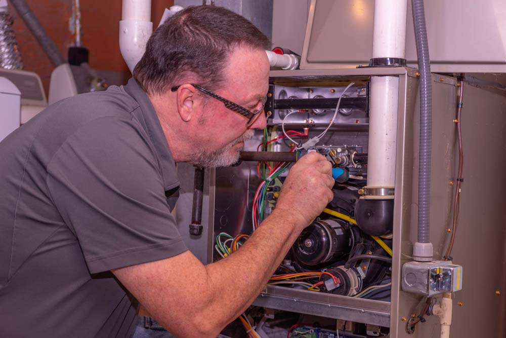 HVAC technician fixing gas furnace