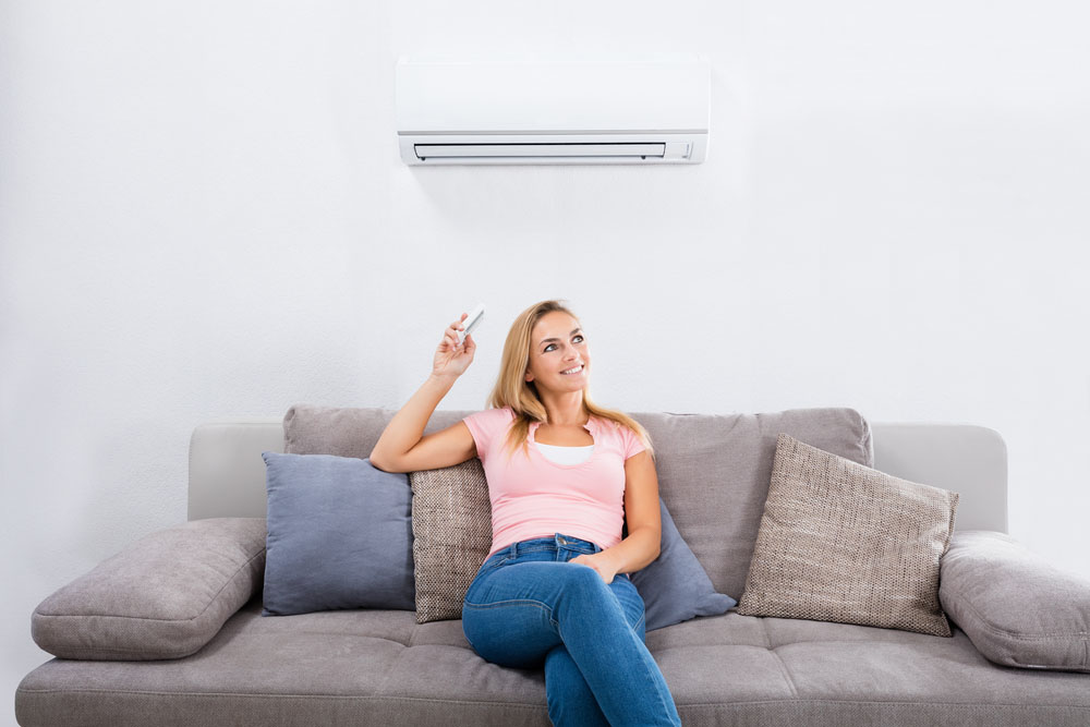 happy woman operating air conditioner Menifee, CA